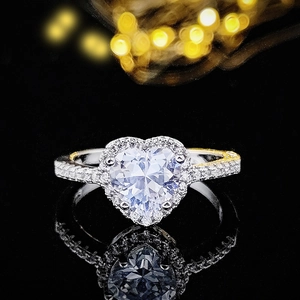 Primer plano detallado de un anillo de diamante corazón con engaste halo en espejo negro