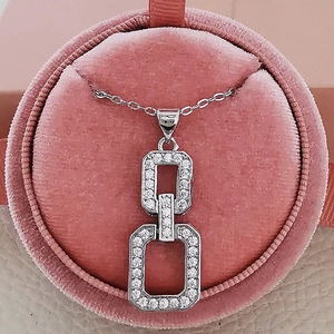 Collier géométrique élégant en argent avec pendentif entrelacé dans un écrin rose