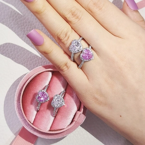 Detail view of heart-shaped gemstone rings with pavé band in a pink velvet jewelry box