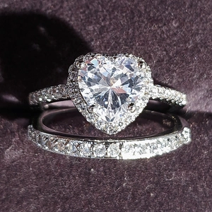 Macro view of heart-cut halo ring set with pave diamonds in silver finish