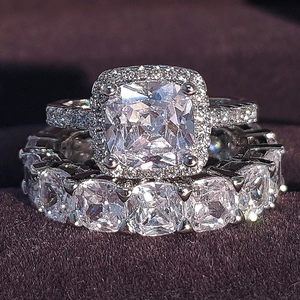 Macro-opname van halo-verlovingsring met kussenslijpsel en eternity-band op paars fluweel