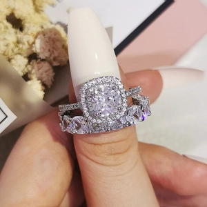 Conjunto de anillos de lujo con halo de corte cojín y alianza de eternidad plateada