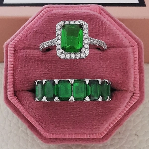 Elegante conjunto de anillos de circón verde esmeralda en caja de terciopelo rosa