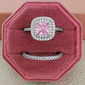 Detalle del set de anillos halo rosa corte princesa en un joyero de terciopelo