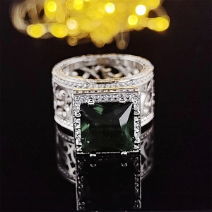 Luxurious wide band emerald cut green gemstone ring with hollow silver patterns