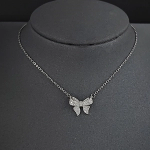 Collier avec pendentif nœud scintillant et franges en cristal sur buste d'exposition