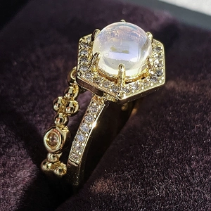 Macro-detail van gouden ring met maansteen, zeshoekige halo en pavé gezette diamanten