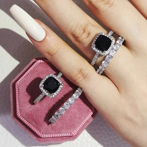 Dettaglio del set anello con pietra nera taglio cushion e fascia pavé in scatola di velluto rosa