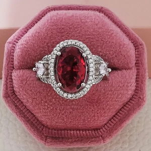Elegant silver ring featuring a large oval ruby center and double halo of zircon stones