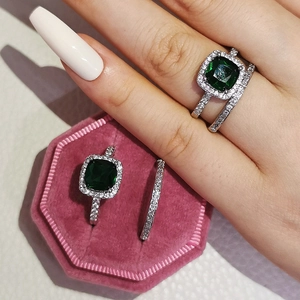 Elegante anello con gemma verde taglio smeraldo e micro-zirconi in scatola di velluto rosa