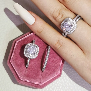 Conjunto de anillos de plata con diamante de corte cojín en un estuche de terciopelo rosa