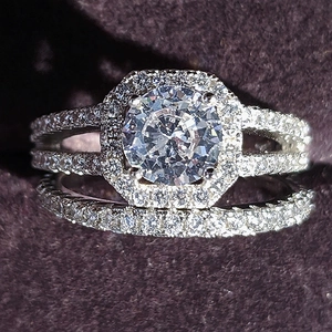 Luxury halo wedding ring set with pavé round center diamond on dark velvet background
