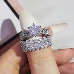 Lujoso juego de dos anillos de plata con solitario clásico de seis garras y bandas pavé