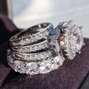 Détail macro d'un ensemble de bagues halo en argent avec cristaux pavés sur velours