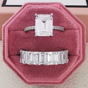 Romantische paarringset met smaragd geslepen steen in een roze fluwelen geschenkdoos