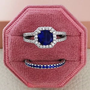 Luxury halo ring set with round deep blue gemstone and silver band in velvet box