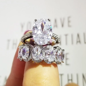Conjunto de anillos de plata con piedras blancas de corte ovalado y bandas de pavé