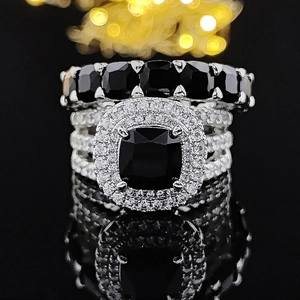 Ensemble de bagues noires carrées avec halo de diamants et reflet sur fond sombre de luxe