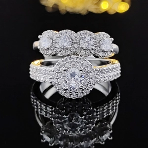 Conjunto de anillos halo con circonita redonda y detalles dorados en fondo de espejo