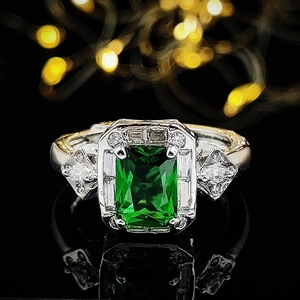 Art Deco ring with rectangular green gemstone and diamond halo on two-tone metal band