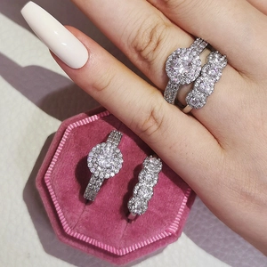 Conjunto de anillos de compromiso halo de plata con piedra redonda y banda de pavé