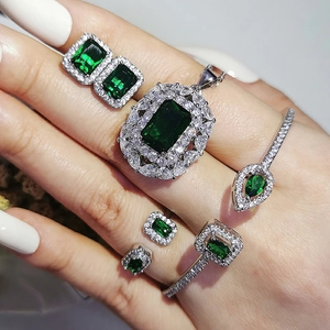 Luxury 4-piece jewelry set featuring emerald green gemstones and silver finish necklace