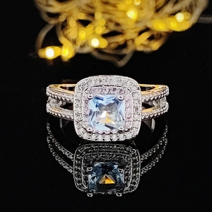 Luxury square halo ring featuring a large clear stone on a reflective black background