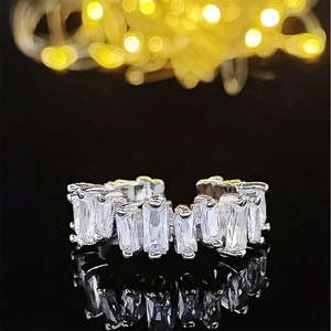 Verstellbarer silberner Ring mit Smaragdschliff-Kristallen vor luxuriösem Bokeh-Hintergrund