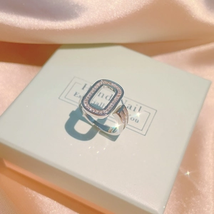 Detailansicht eines silbernen Rings mit Zirkonia-Besatz auf einer grünen Geschenkbox