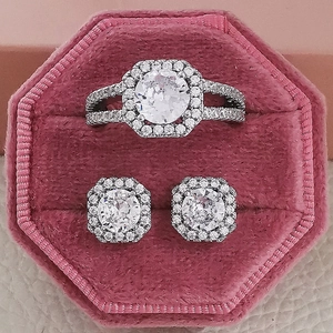 Luxury silver-tone jewelry set with round stones in a pink velvet ring box