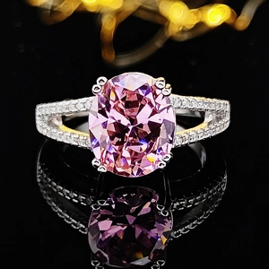 Macro shot of oval pink gemstone ring with split shank and diamond pave detail