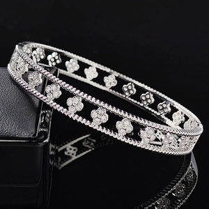 Elegant silver clover bracelet with crystal pave setting on a black mirror reflective background