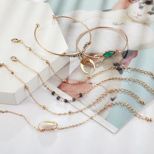 Bohemian gold bracelet set featuring crescent moon charms and natural shell pendants