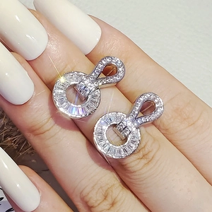 Sparkling hoop earrings with pavé baguette cubic zirconia shown on finger for scale
