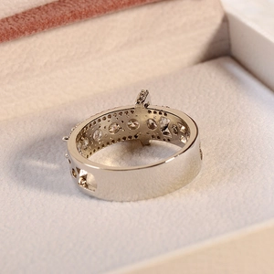 Macro shot of silver wide band ring with zircon pave setting and hollow geometry