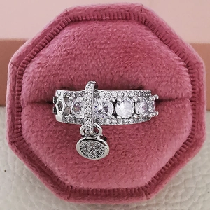 Elegant silver ring with sparkling cubic zirconia stones and a round dangling charm