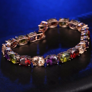 Makroaufnahme von ovalen bunten Edelsteinen in Roségold-Krallenfassung am Armband