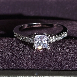 Primer plano de anillo de plata de lujo con corte princesa sobre terciopelo lila