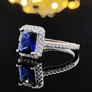 Elegant silver square ring with a rectangular blue gemstone and sparkling micro-pave diamonds