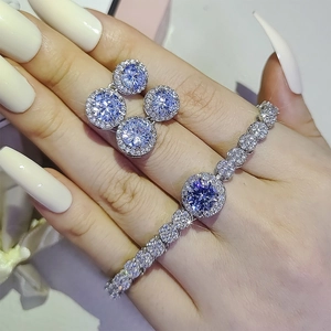 Schmuckset mit blau-violetten Halo-Ohrsteckern und einem funkelnden Tennisarmband