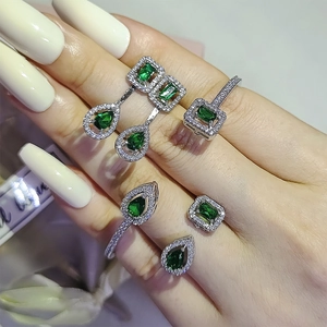Macro de conjunto de joyas en plata con piedras verde esmeralda y pavé de circonitas
