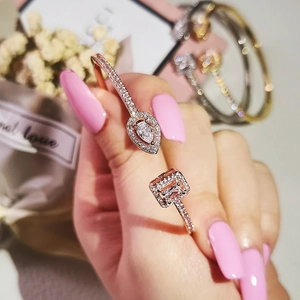 Close-up of rose gold open bracelet with asymmetric square and teardrop zircon accents