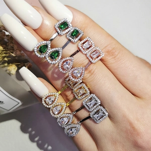 Detalle de set de anillos ajustables con piedras talla pera y esmeralda en mano de modelo