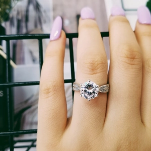 Vista detallada de un anillo de lujo en plata con circón redondo en mano femenina