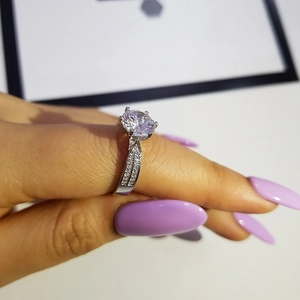 Primer plano de un anillo solitario redondo de seis garras con doble hilera de piedras