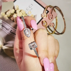 Detail of adjustable silver open bangle with pear and square-cut zircon stones on a model wrist