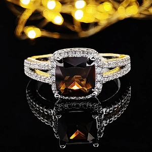 Dettaglio macro dell'anello vintage con pietra marrone quadrata e accenti di diamanti