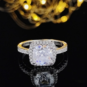 Macro de un anillo de lujo con circón cuadrado y halo brillante sobre fondo negro reflectante