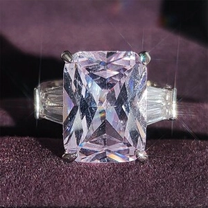 Macro di un anello di lusso con gemma rosa e diamanti laterali a trapezio