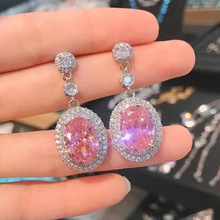 Makroansicht der rosa ovalen Zirkon-Ohrringe mit doppelter funkelnder Strass-Einfassung